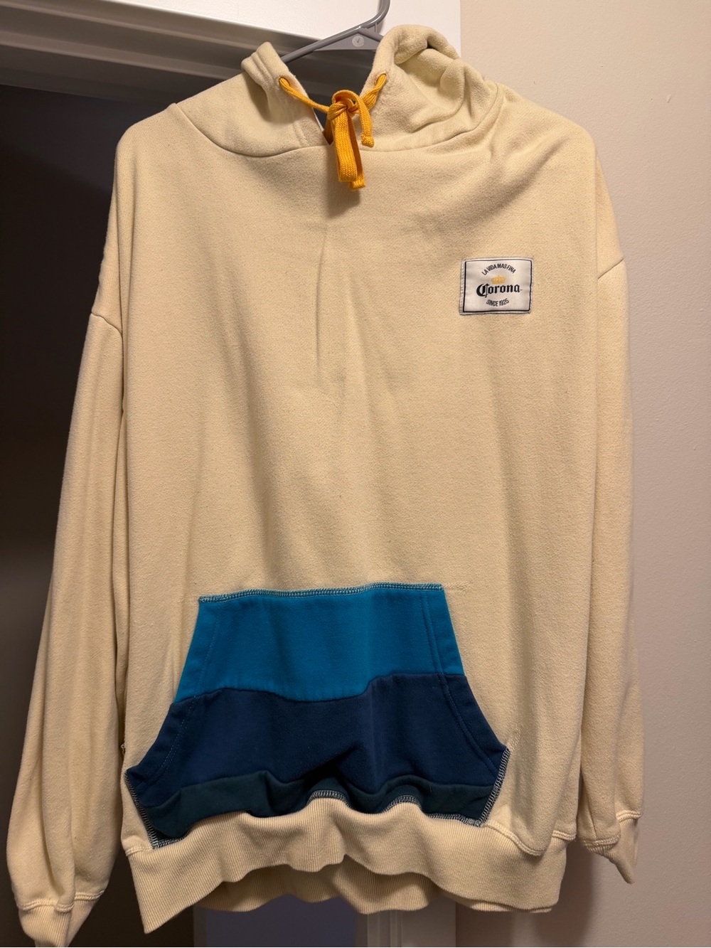 Corona Cream Crewneck Sweater with Blue Pocket Panels and Yellow Drawcord